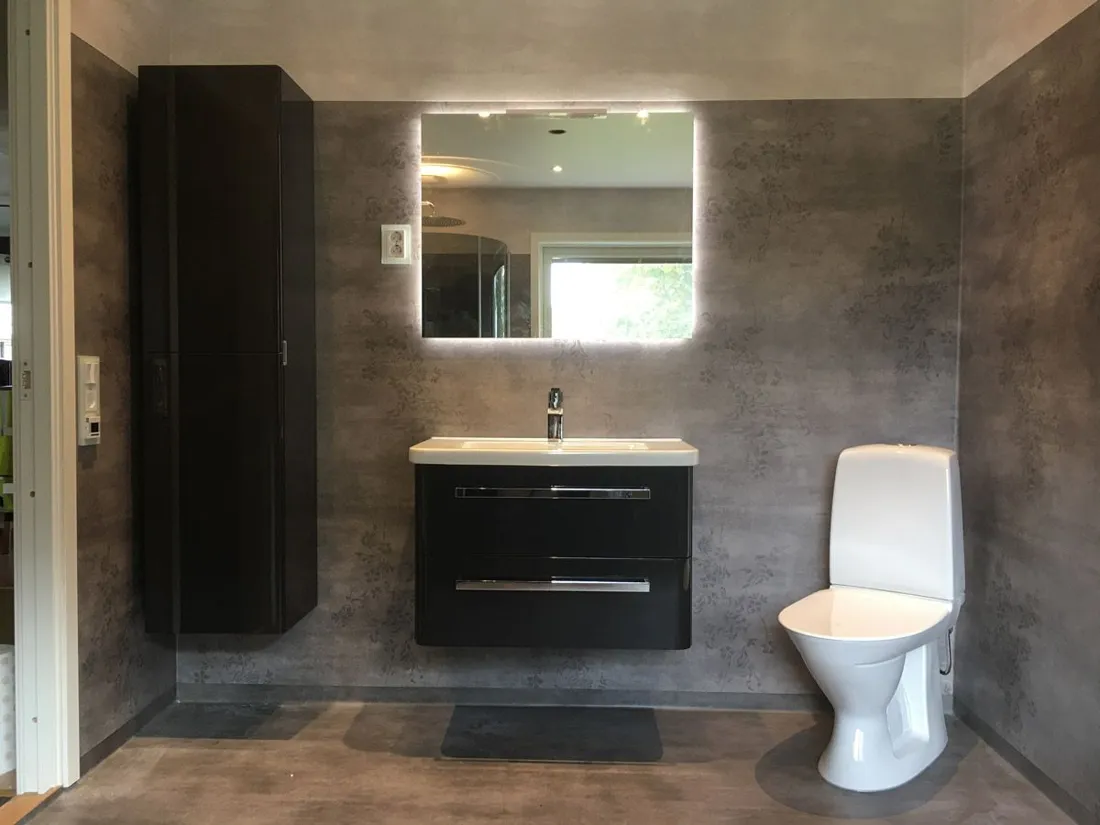 Badrum i mörk kakel med kommod